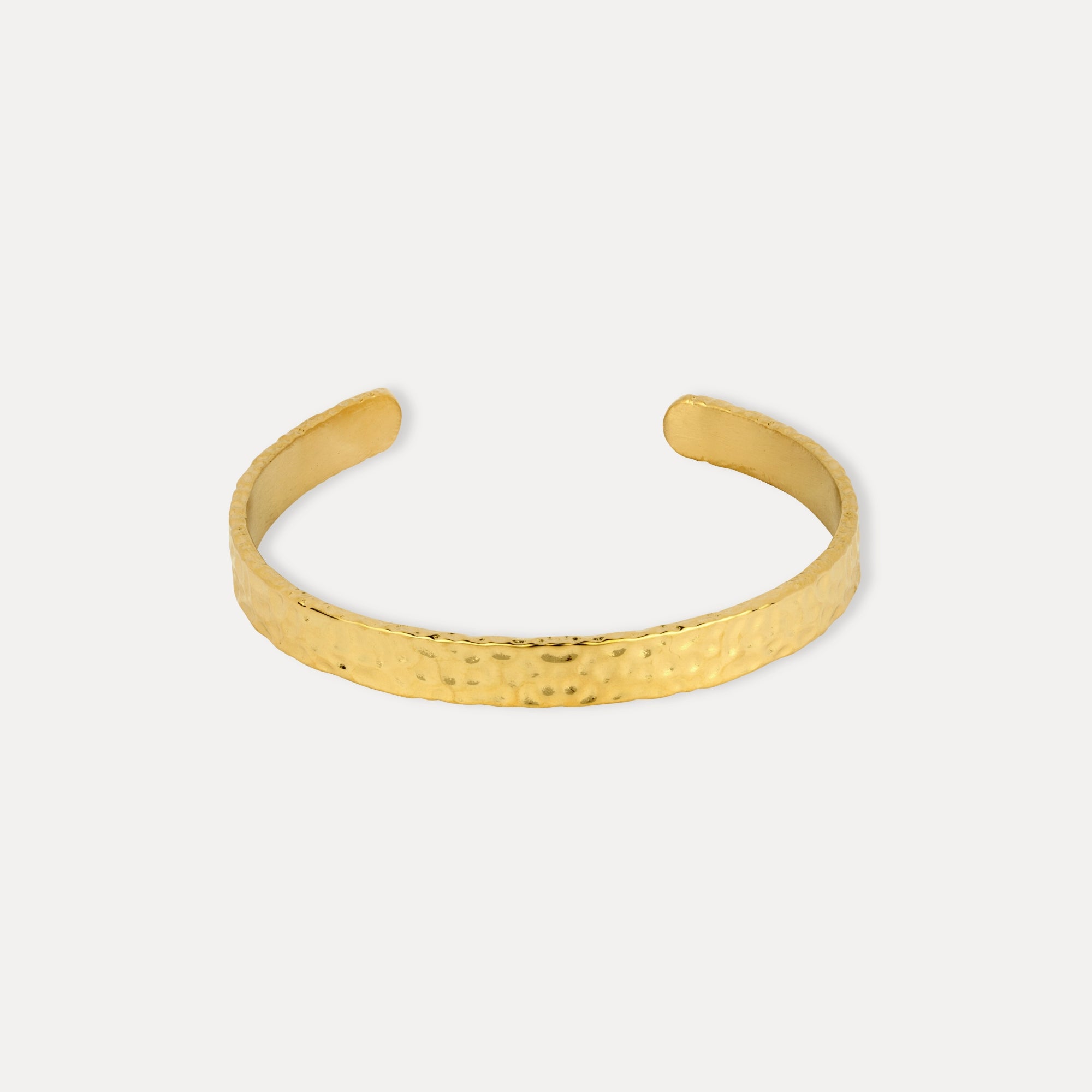 Gold bracelet on a light gray background