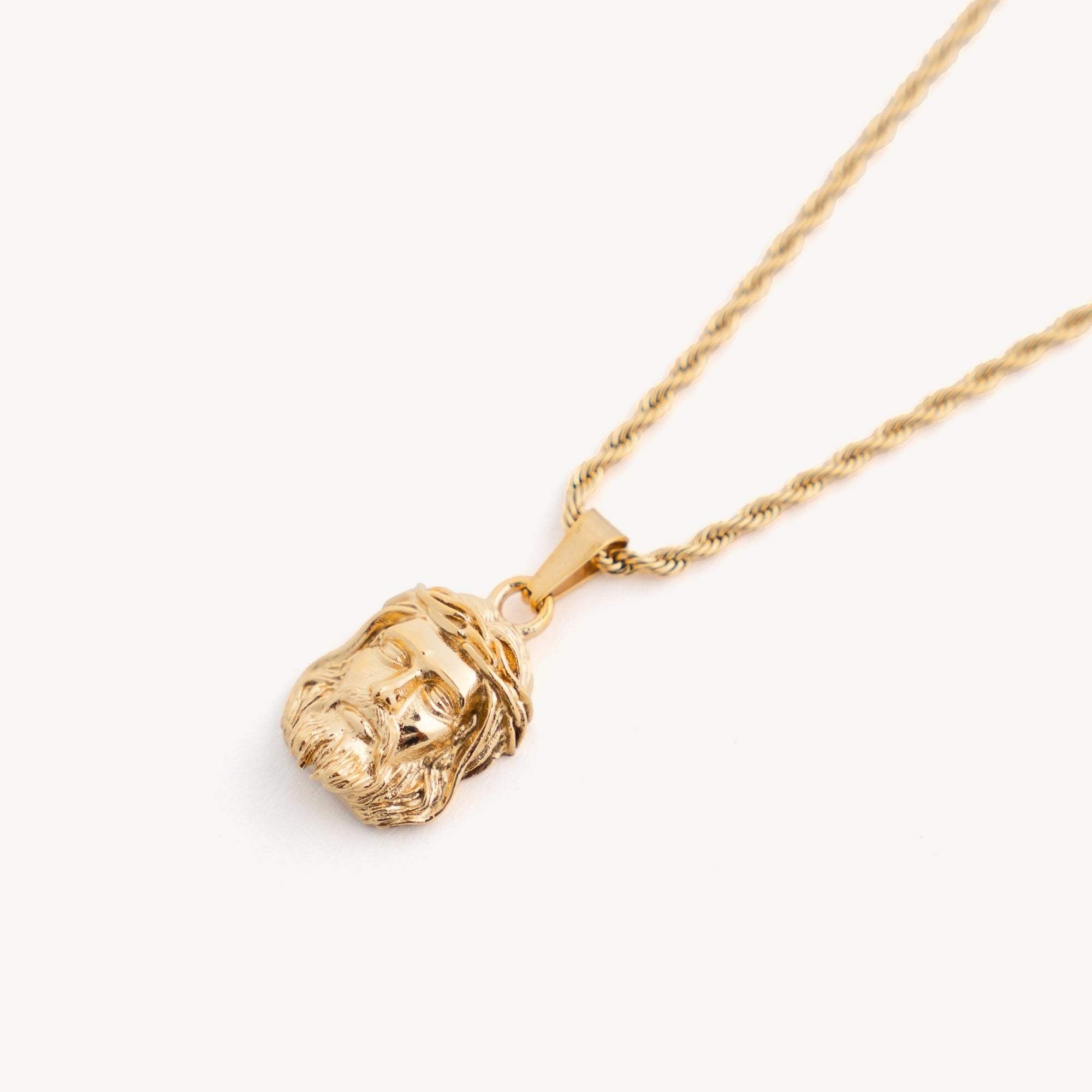 Gold lion head pendant necklace on a white background