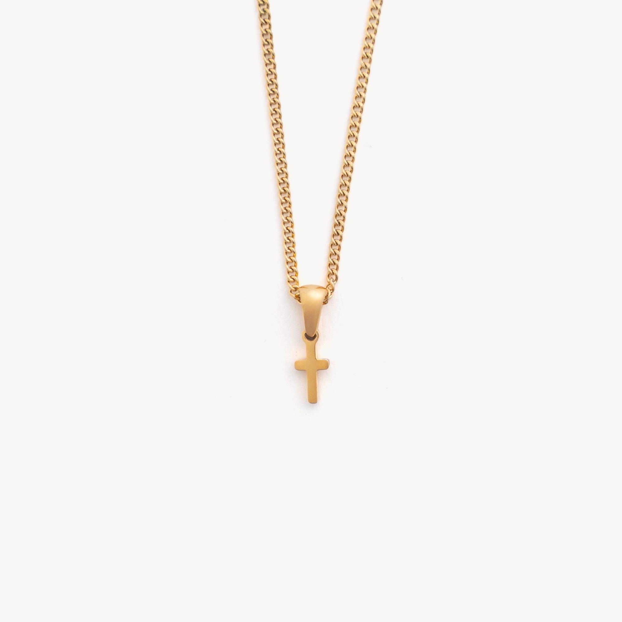 Gold necklace with a small cross pendant on a white background