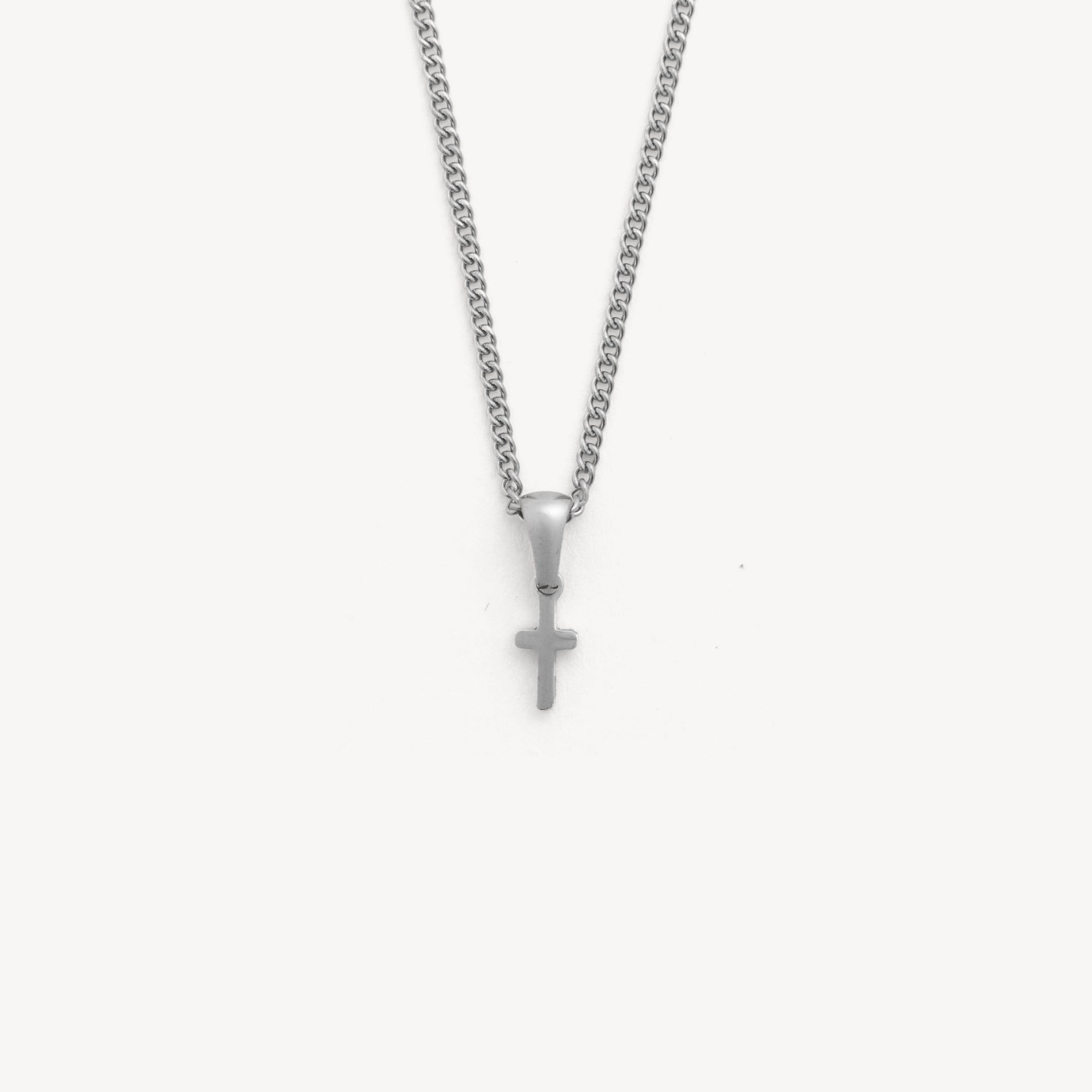 Silver necklace with a cross pendant on a white background