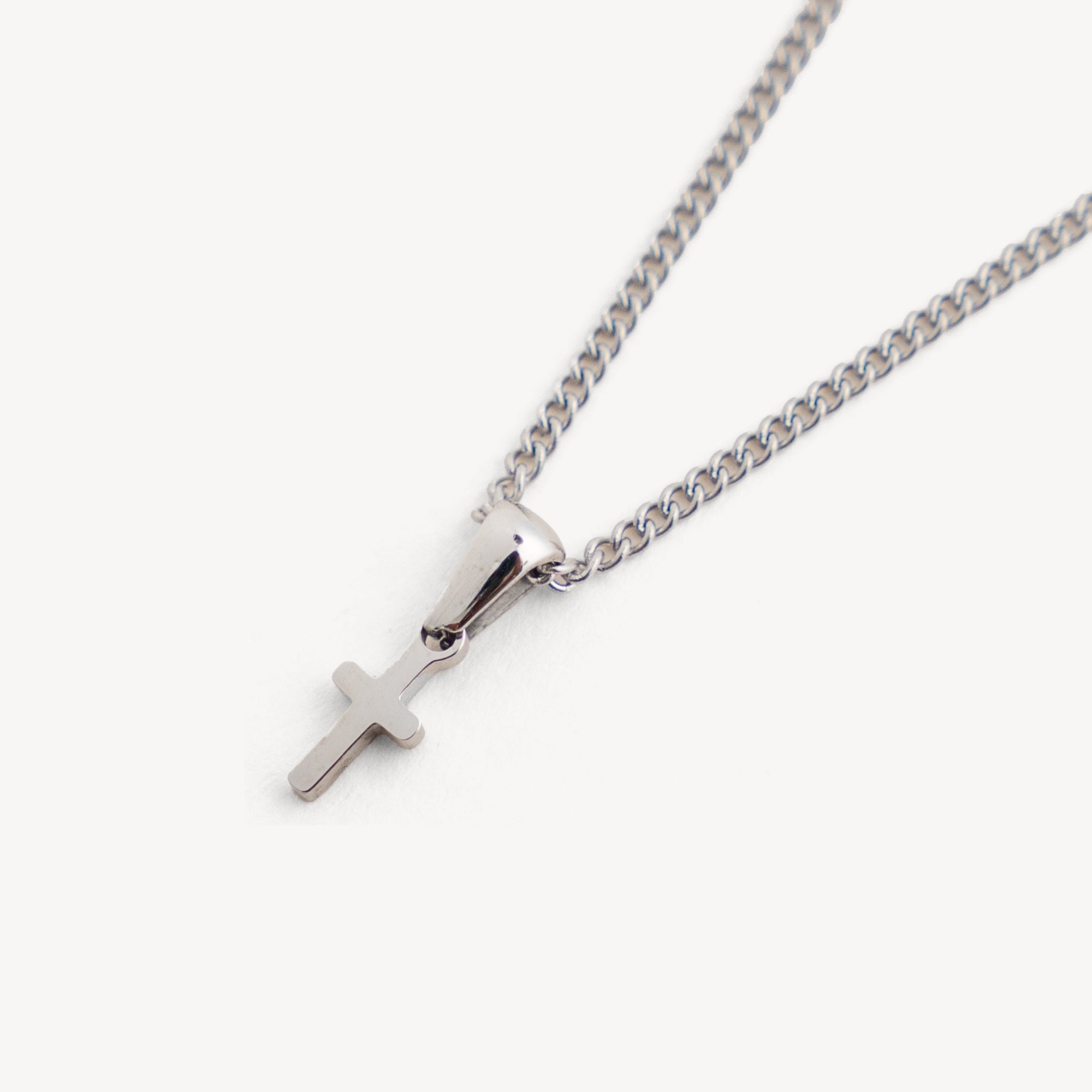 Silver necklace with a cross pendant on a white background