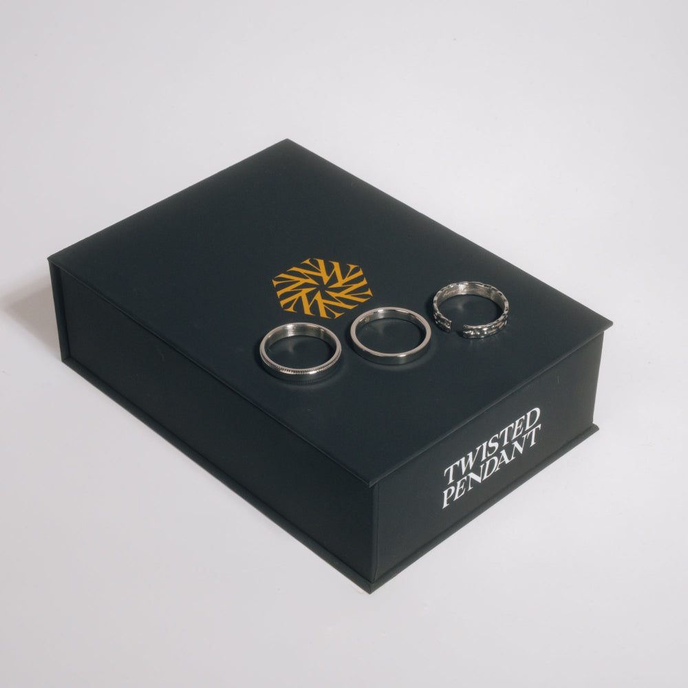 Black jewelry box with 'Twisted Pendant' branding featuring three silver rings on a white background.