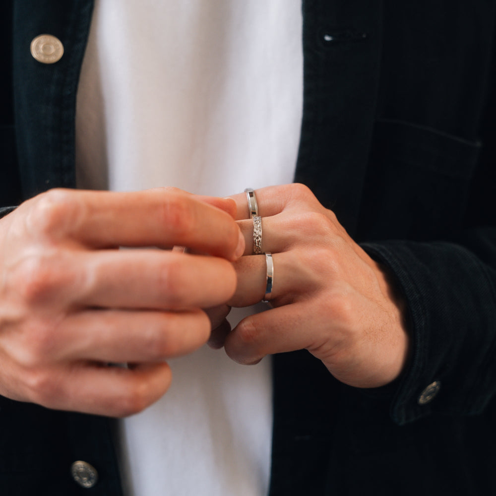 Close-up of hands wearing multiple rings with a blurred background