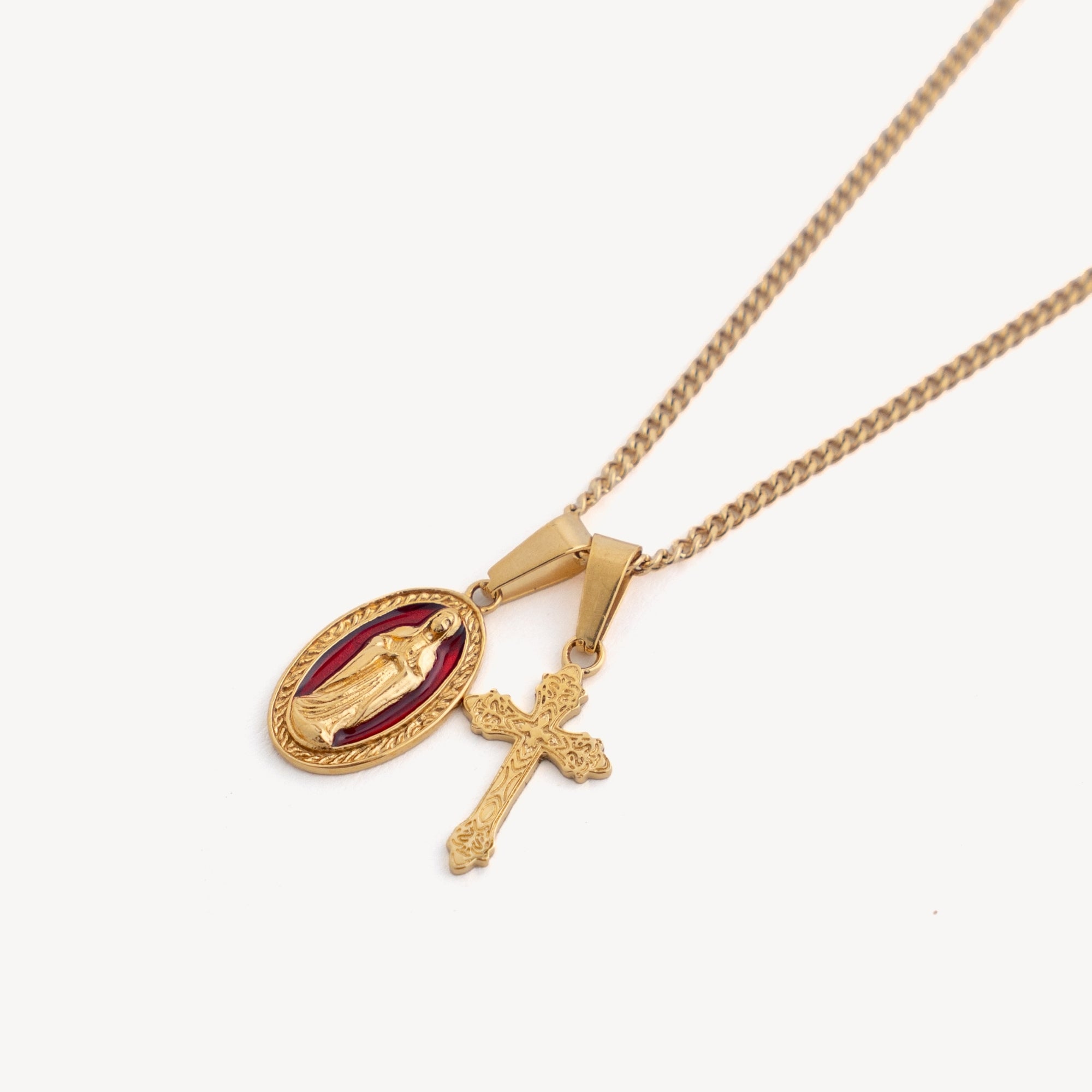 Gold necklace with a pendant and cross on a white background