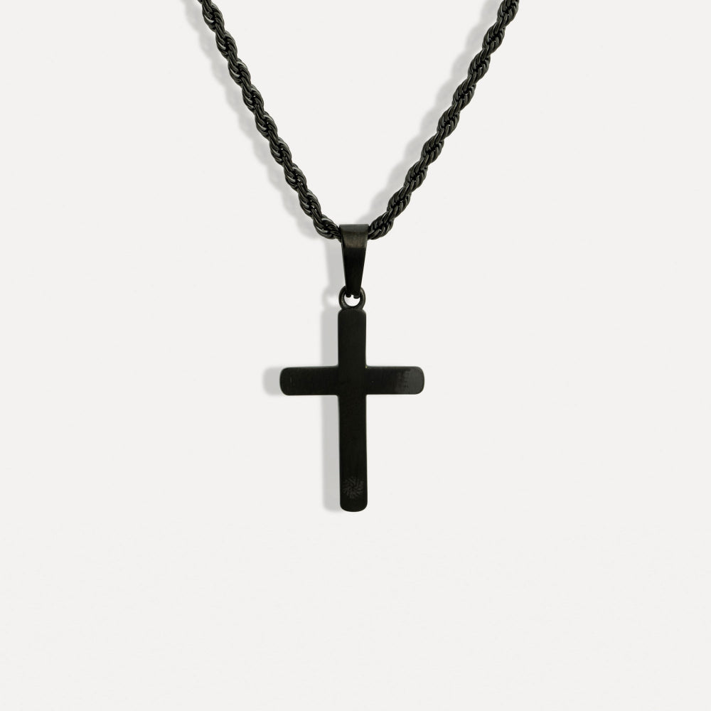 Black cross pendant on a chain against a white background