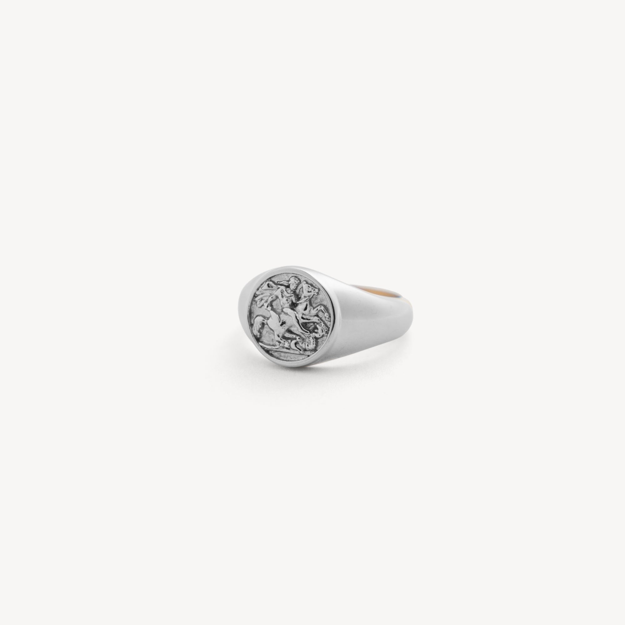 Silver ring with a circular design on a white background