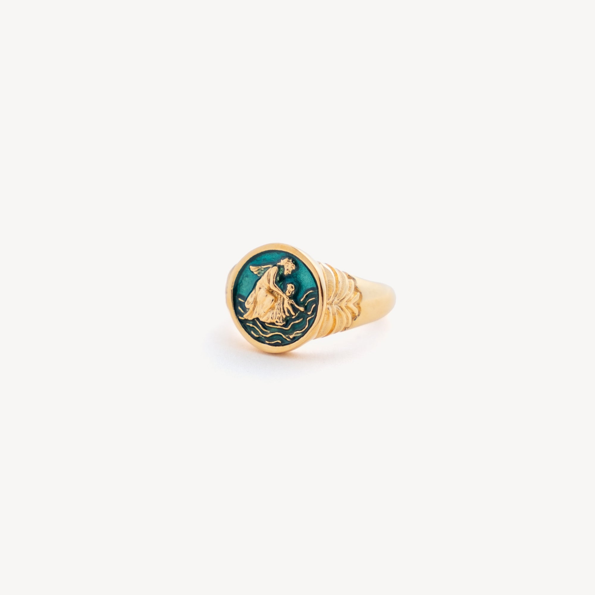 Gold ring with a green gemstone and engraved design on a white background