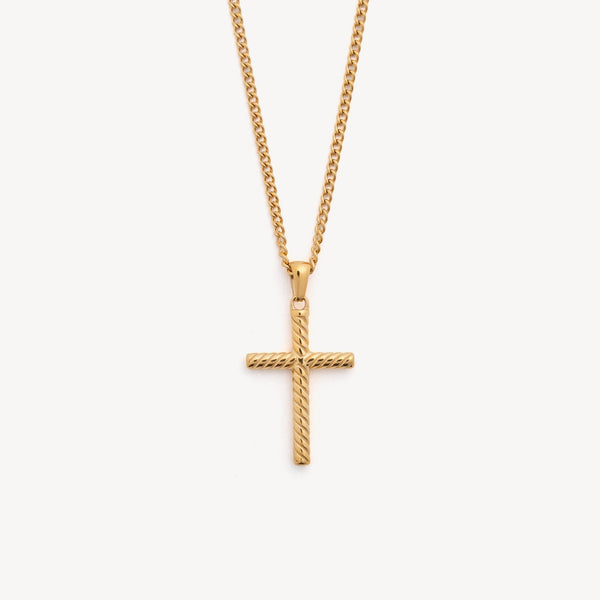 Gold cross necklace on a light gray background