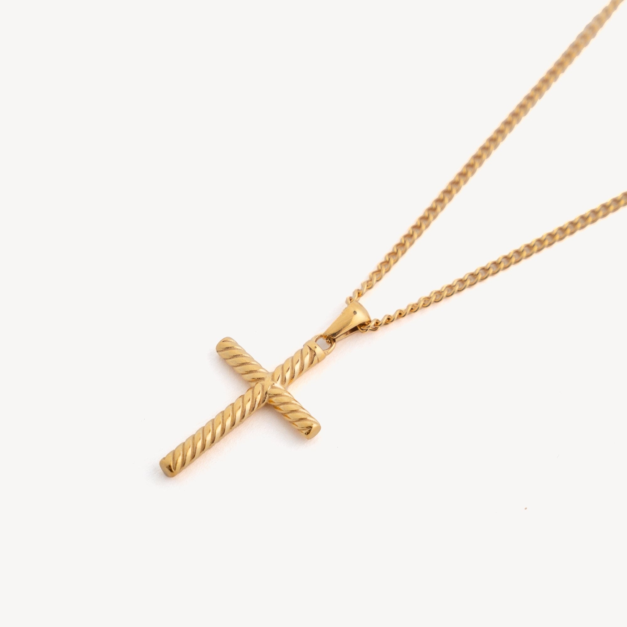 Gold cross necklace on a white background