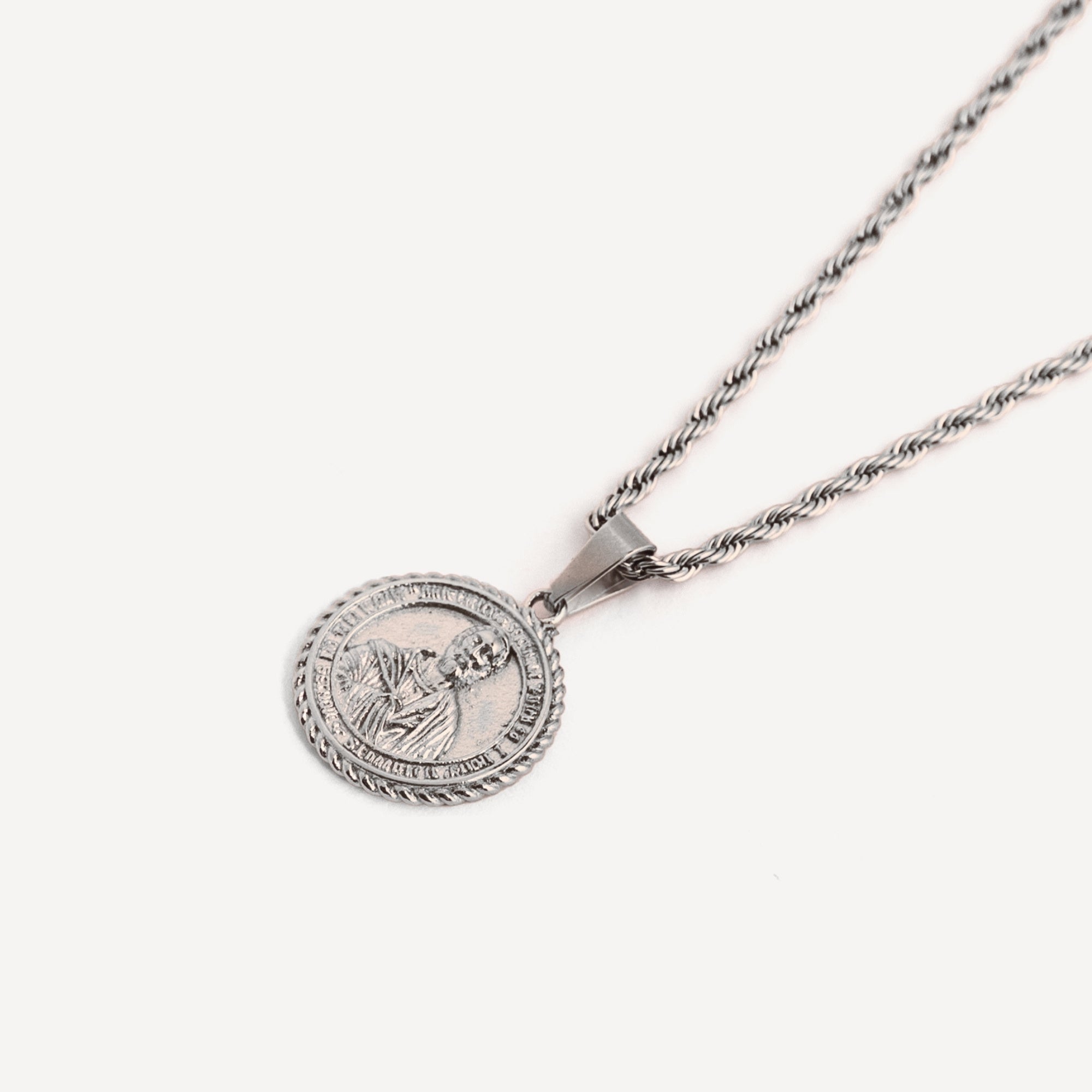 Silver necklace with a round pendant on a white background