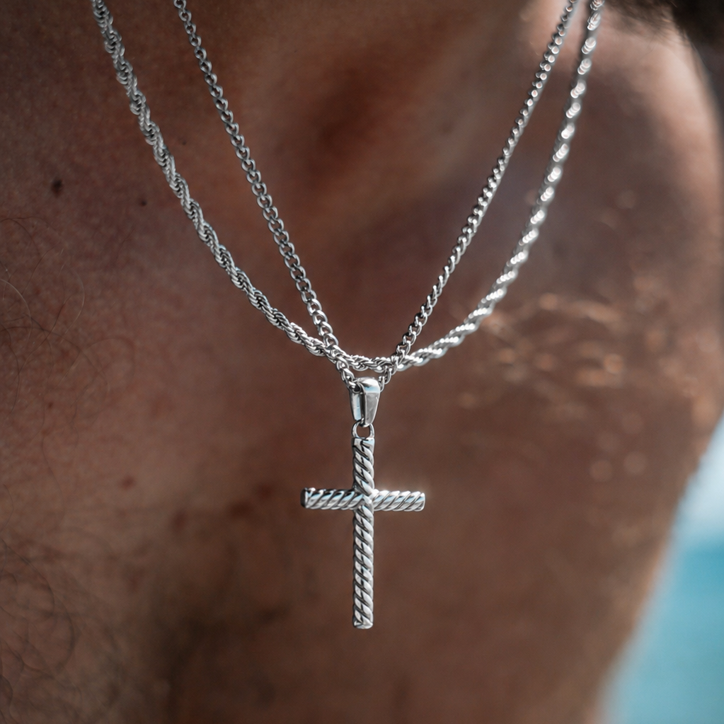 Silver cross necklace on a person's neck with a blurred background